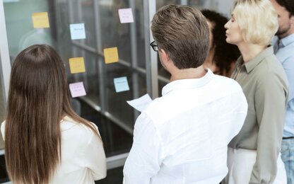 Gruppe von Geschäftsleuten, die Haftnotizen zur Anwendung der agilen Methodik verwenden