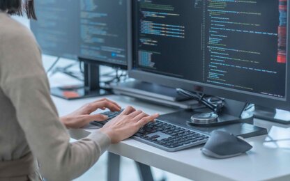 Programmiererin arbeitet mit Softwaredaten vor einem Monitor